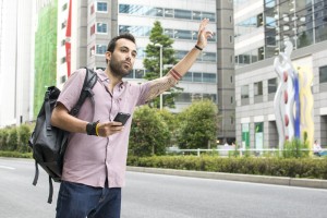 Young,White,Man,Holding,Cellphone,Hailing,Uber,Taxi