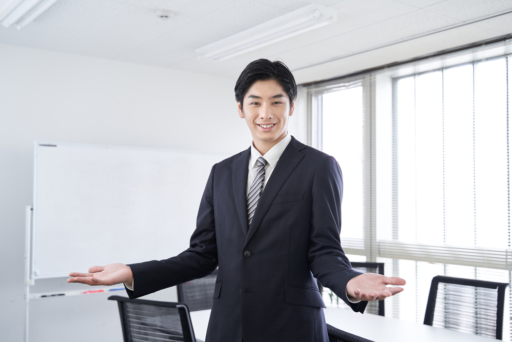 A,Japanese,Male,Businessman,Smiles,And,Spreads,His,Hands,In