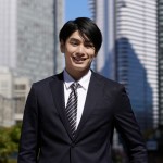 A,Smiling,Japanese,Male,Businessman,Stands,In,An,Office,District.