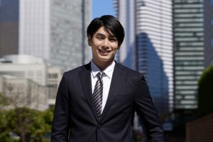 A,Smiling,Japanese,Male,Businessman,Stands,In,An,Office,District.