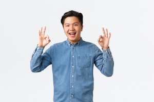 Smiling,Satisfied,Asian,Man,With,Braces,In,Blue,Shirt,,Showing