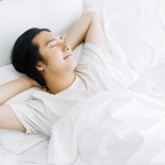 Top,View,Of,Young,Asian,Man,Smiling,While,Sleeping,In