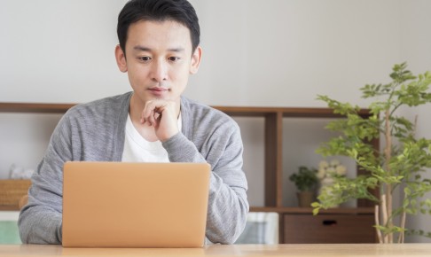 Asian,Man,Using,A,Computer,In,The,Living,Room